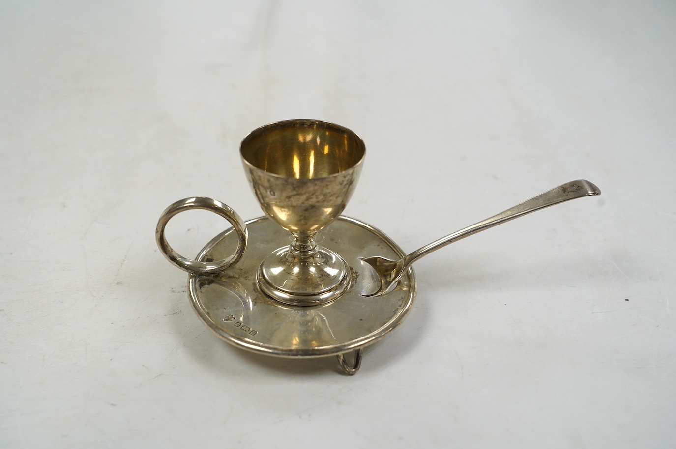 An Edwardian silver egg cup on stand, Birmingham, 1904, 67mm, together with a George III associated spoon. Condition - fair